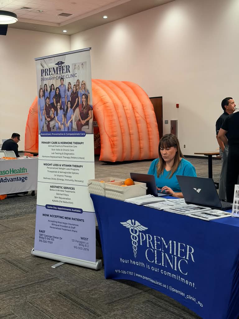 Premier staff at a branded clinic table and banner at a wellness fair