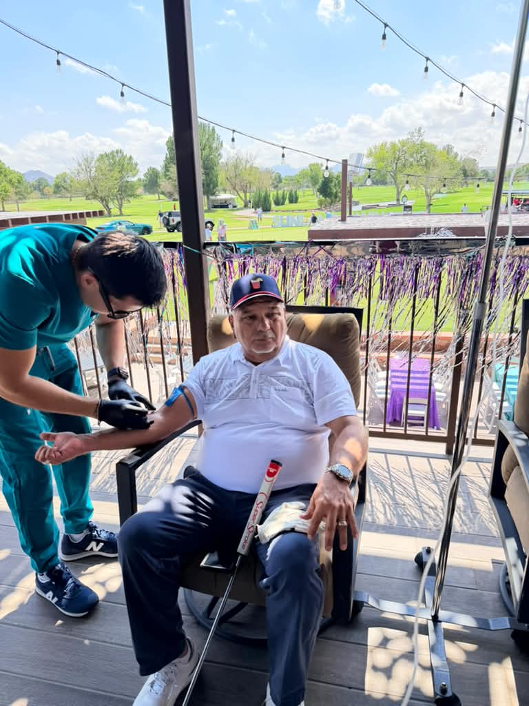A Premier team member attending to a seated client on an outdoor terrace